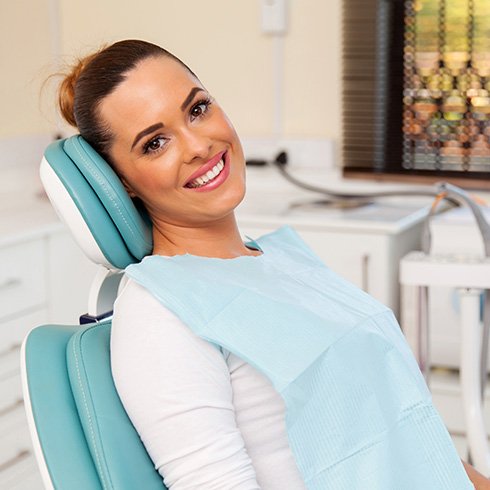 Woman sitting back in dental chair and smiling