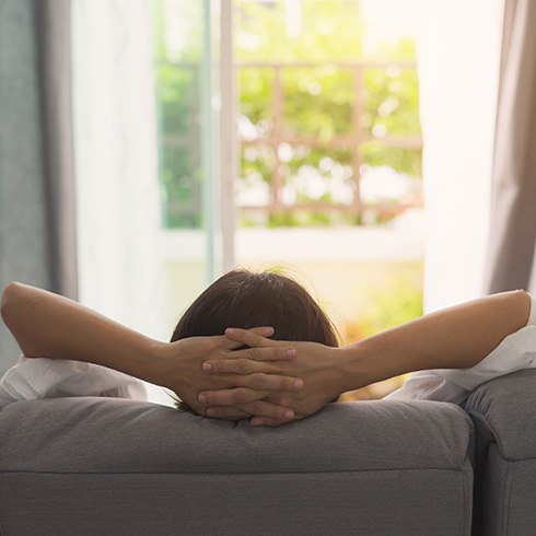 Woman relaxing on couch looking out window