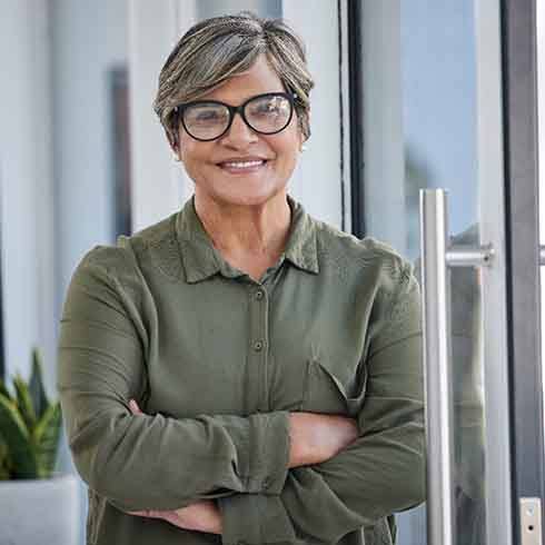 a woman with glasses standing in front of a door