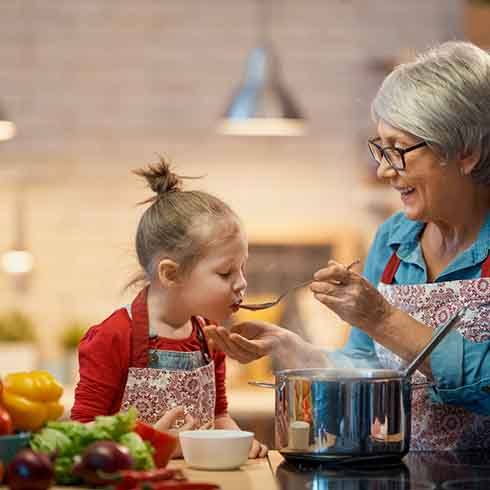 a grandparent cooking for her grandchild