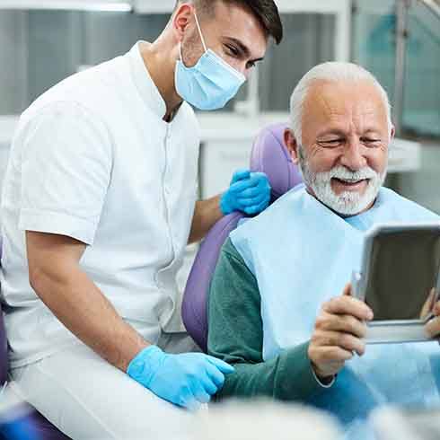 a man visiting his dentist and looking in a mirror