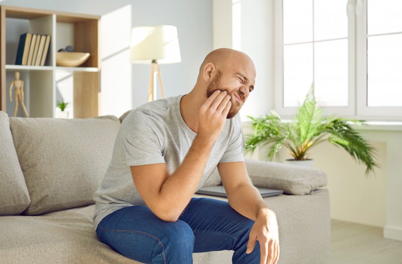 Patient holding their cheek due to a dental emergency